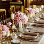 Long table served with porcelain crockery and shining cutlery served with pink flowers