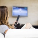 Young woman watching TV in the room